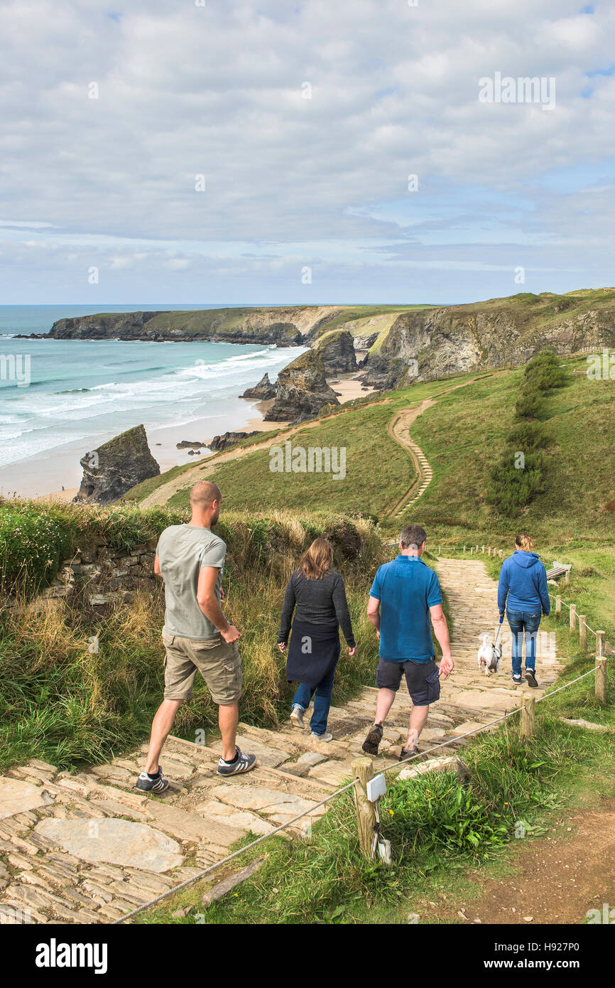 Tourists walk along the South West Coastal Path towards Bedruthan Steps in Cornwall. Stock Photo