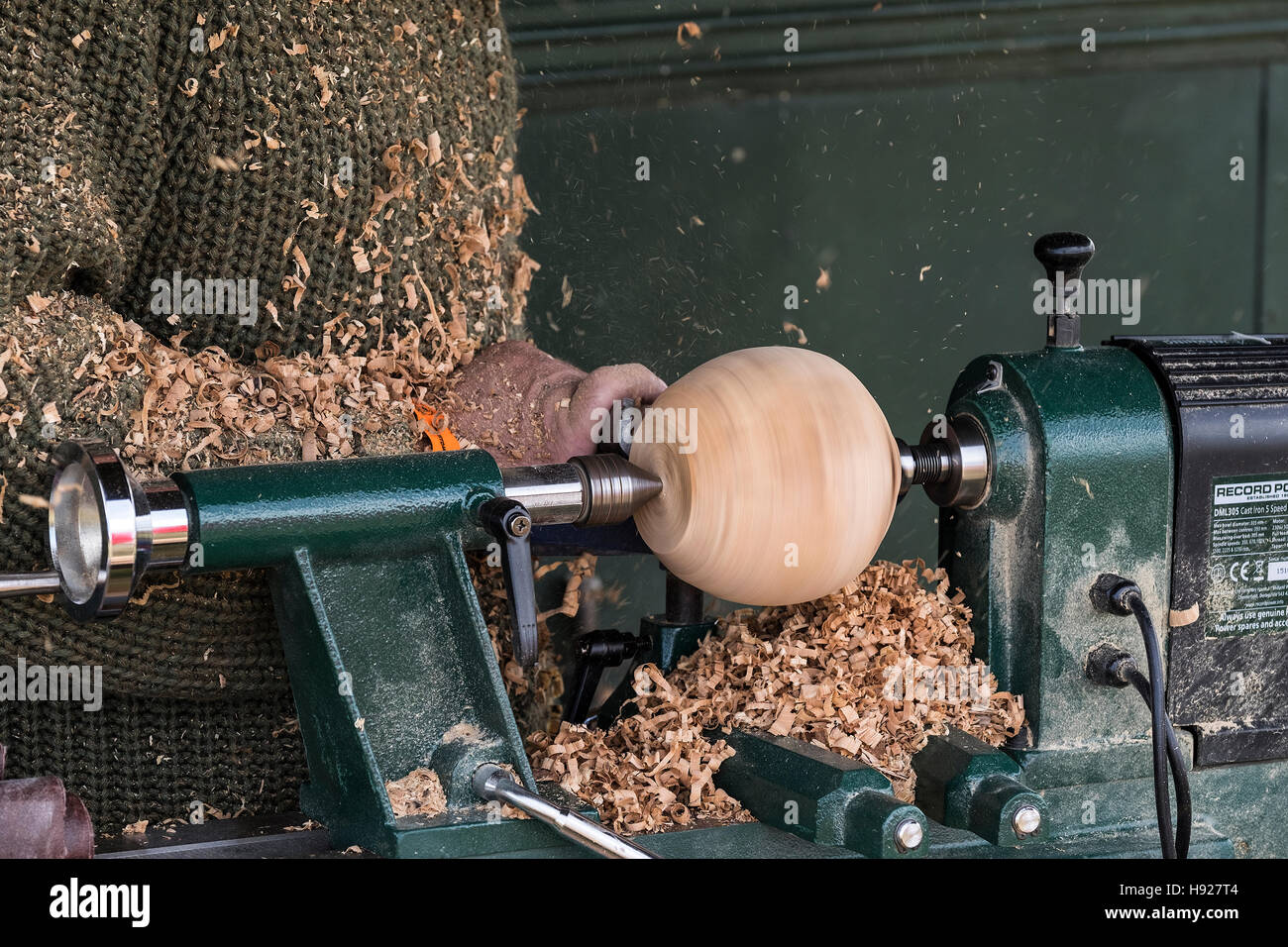 A wood turner turning a sphere on a lathe. Stock Photo