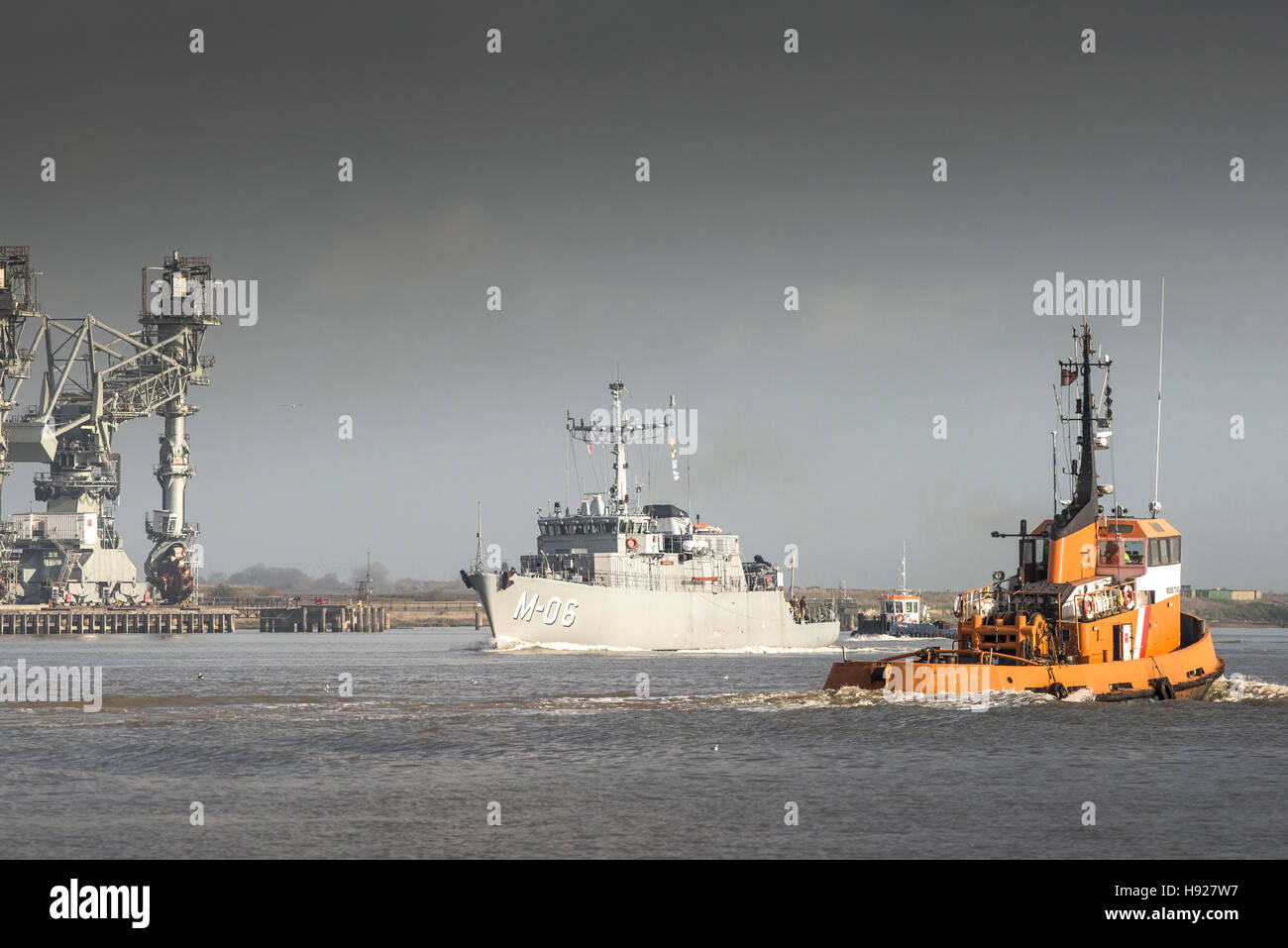 The Boss Tug passes the NATO Alkmaar class minehunter LVNS Talivaldis as she steams downriver on the River Thames. Stock Photo