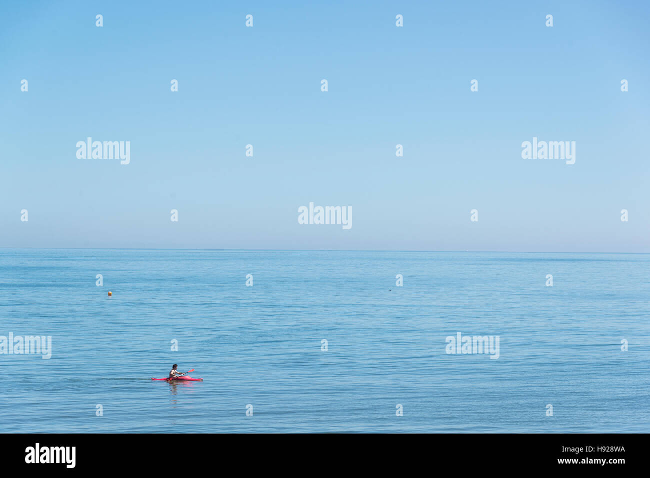 A man canoeing in a calm sea Stock Photo - Alamy