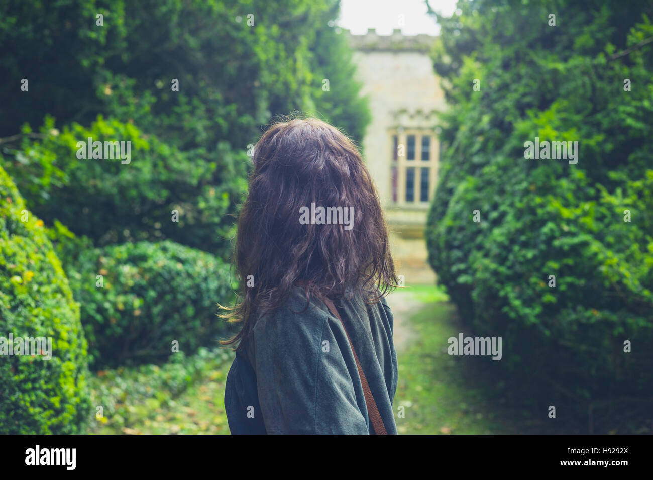 A young woman is exploring a formal garden and stately home Stock Photo ...