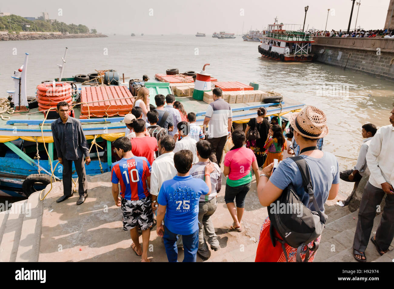 Tourists getting onto a rickety boat to go to the Elephanta Island in Mumbai. Stock Photo