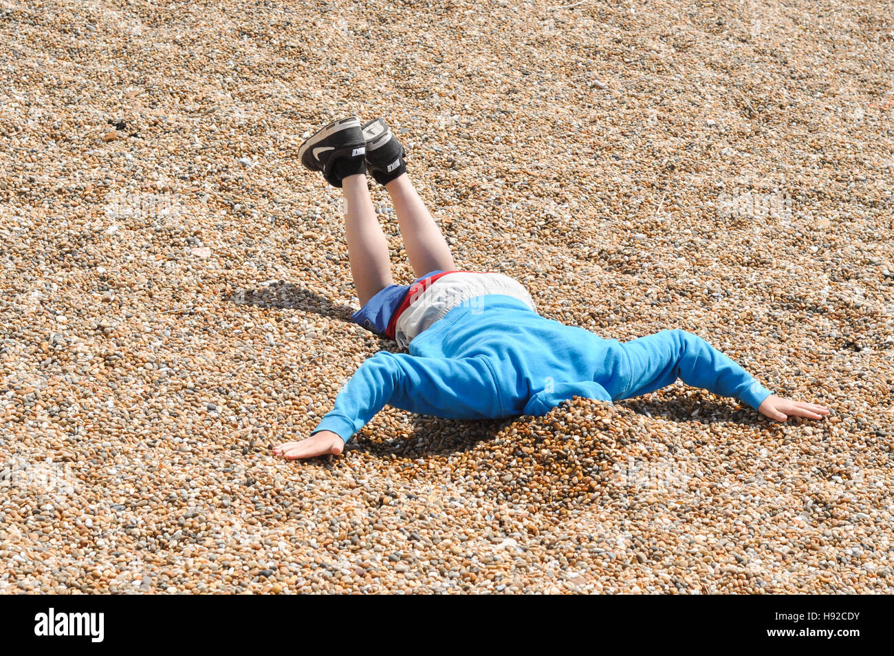 Chesil beach pebbles young boy playing with the shingle pebbles