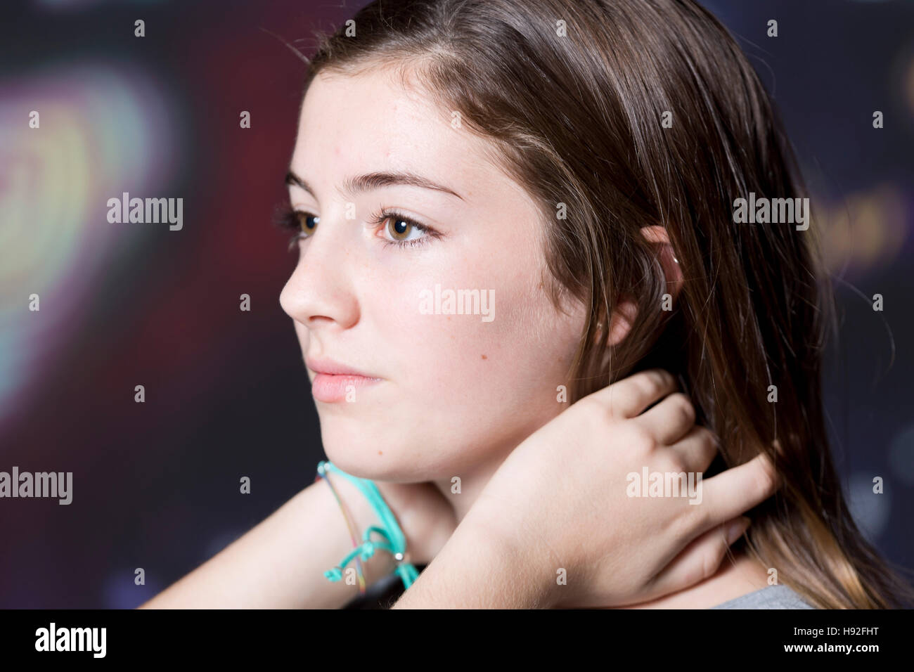 Portrait of adolescent touching hair, lit with flax of study abroad at night. Stock Photo