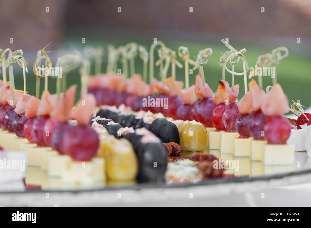 Catering banquet table with baked food snacks, sandwiches, cakes, cups
