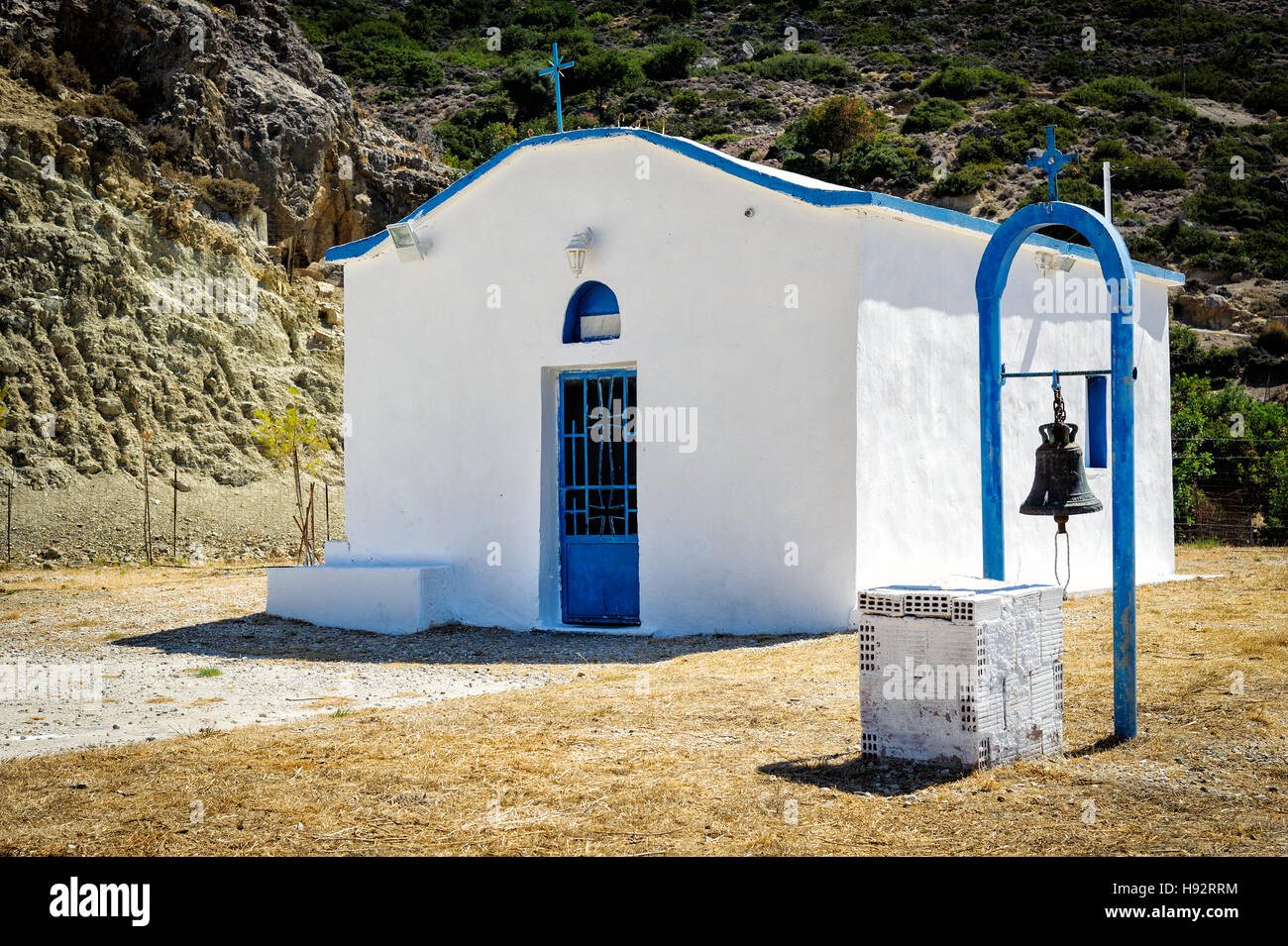 White church with iron bell in mountains of crete island, Greece Stock Photo