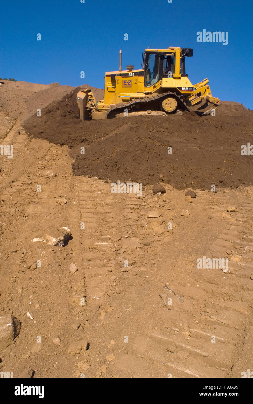 Bulldozer spreading soil on hillside Stock Photo