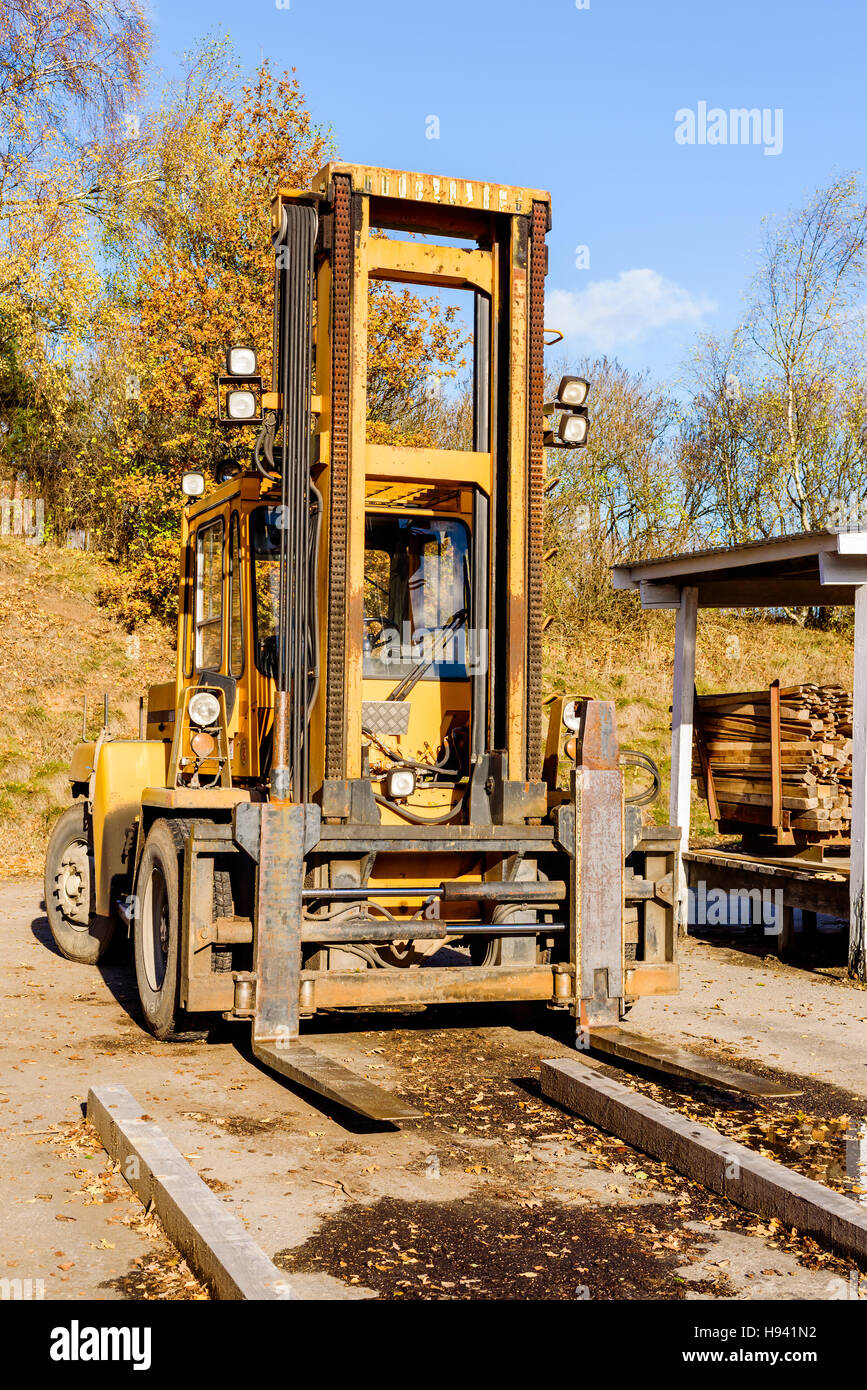 Brakne Hoby, Sweden - October 29, 2016: Documentary of public access industrial area. Large yellow forklift parked outside sawmill in fall. Stock Photo