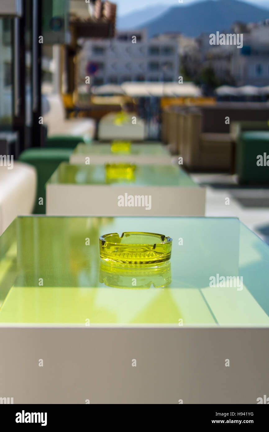 An empty table with an ashtray in a street restaurant. Focus on the foreground. Stock Photo