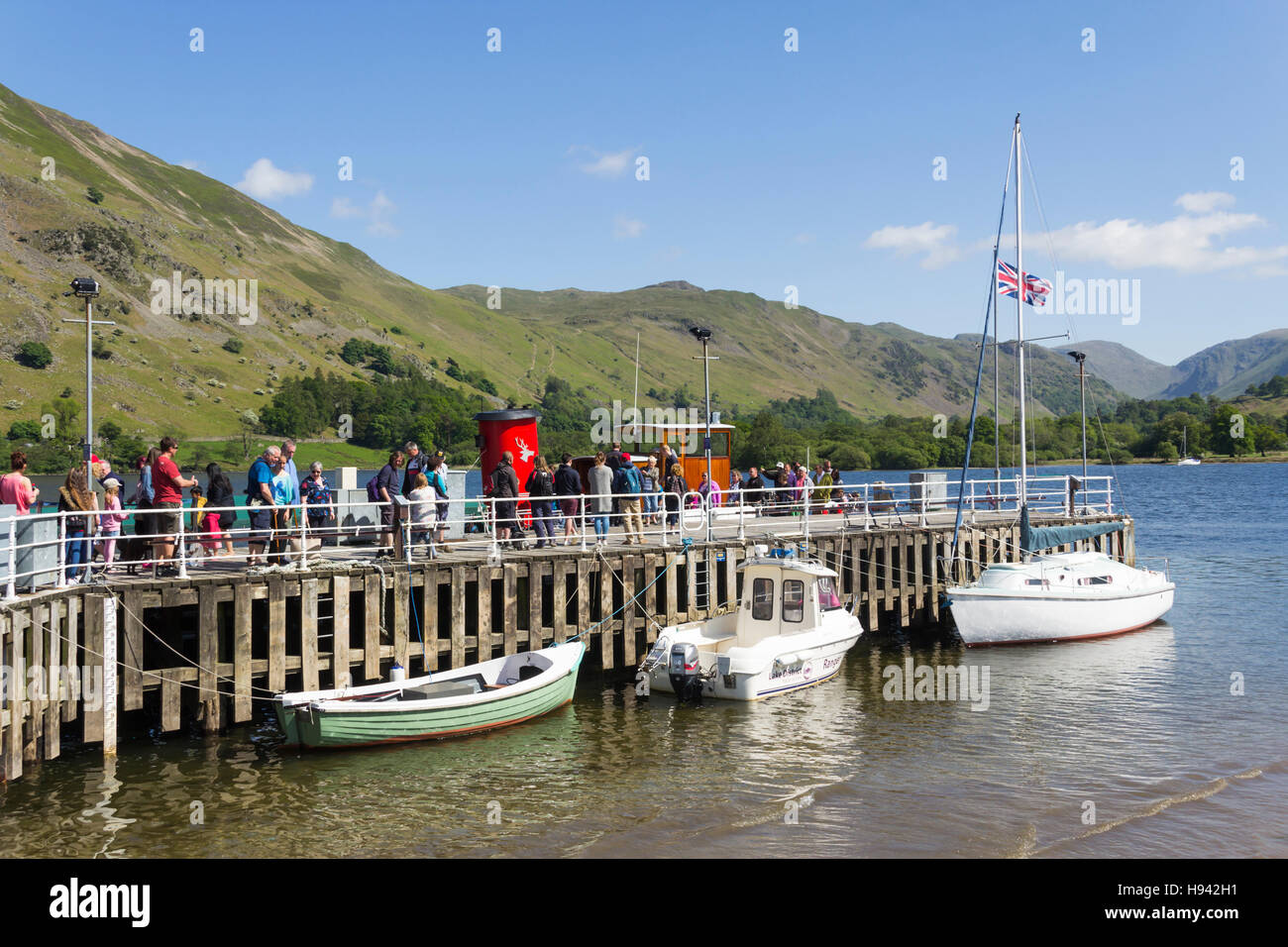 Passengers for Pooley Bridge gather on Ullswater Steamers Glenridding pier, Cumbria, while arriving passengers disembark. Stock Photo