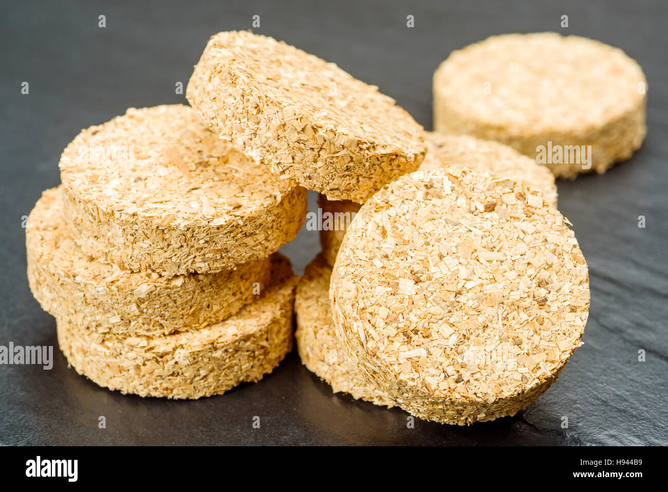 Stacks of hardwood smoker bisquettes made of wood chips. Stock Photo