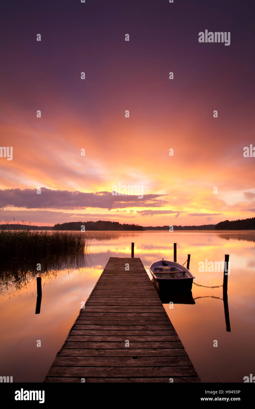 Sunrise at Lake Rheinberger, rowing boat moored beside pier, Rheinsberg ...
