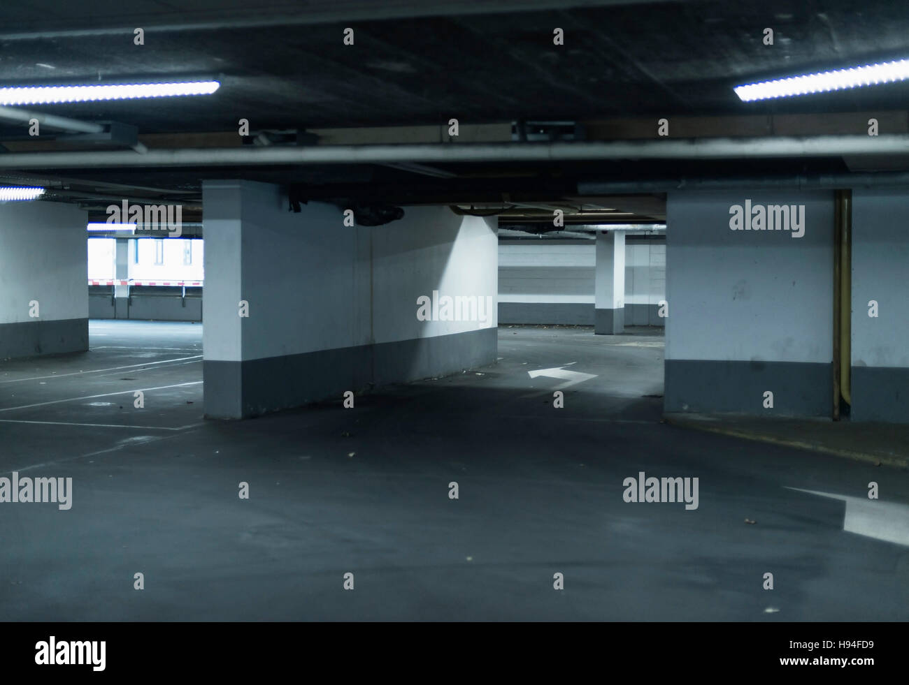 Empty Parking Garage Illuminated By Fluorescent Lights Stock Photo