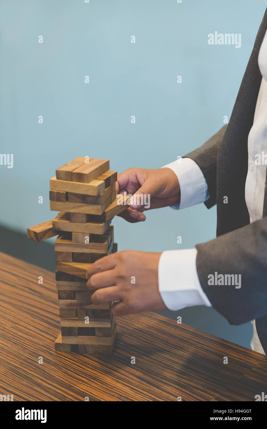 planning, risk and strategy in business, businessman gambling placing wooden block on a tower Stock Photo