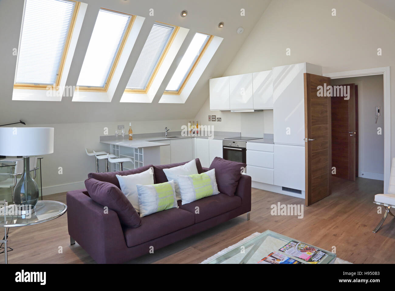 Interior of a modern attic apartment in a new super-insulated residential block. Shows living area and kitchen breakfast bar Stock Photo