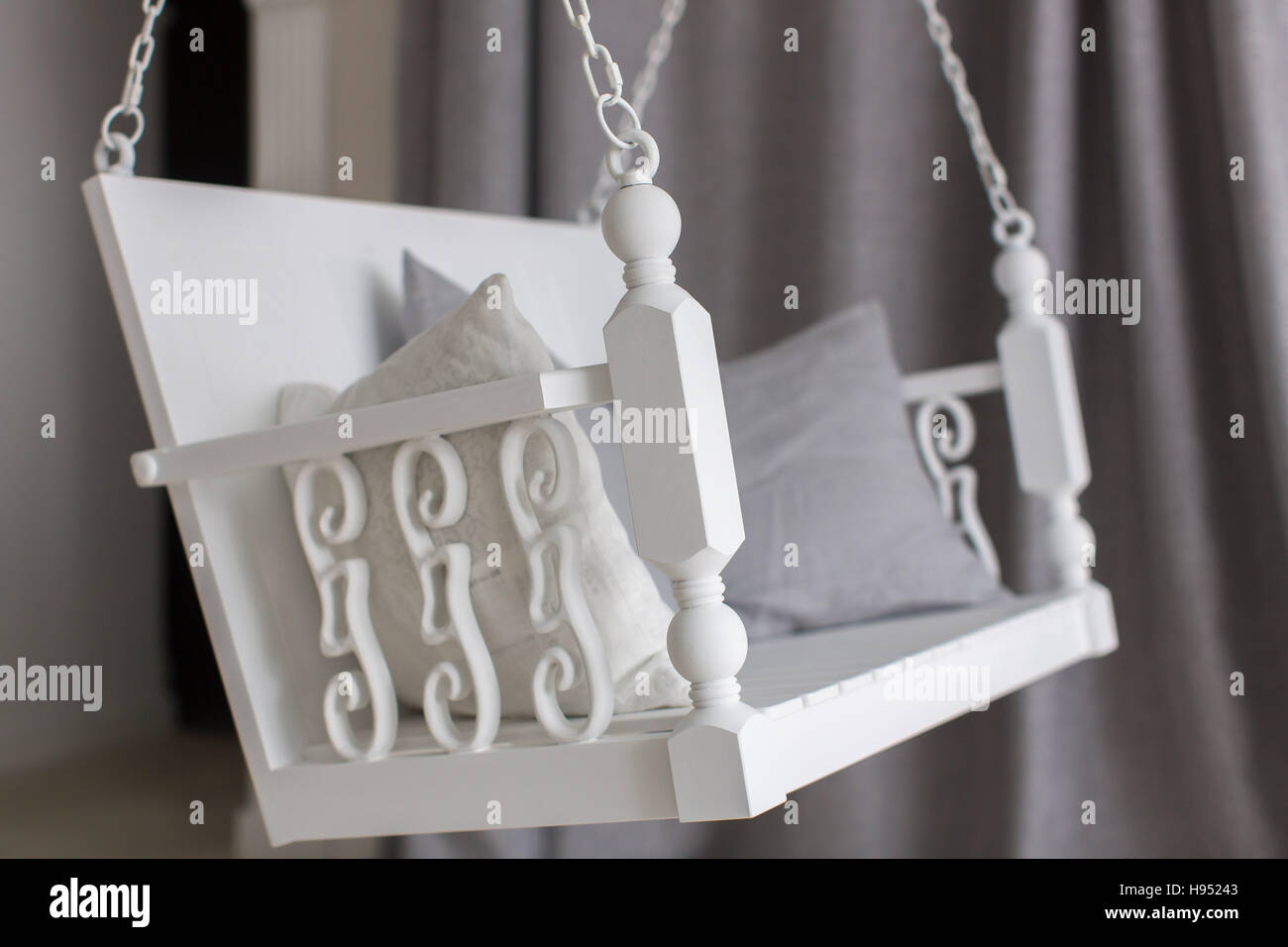 White swing with pillow wooden handles Stock Photo Alamy
