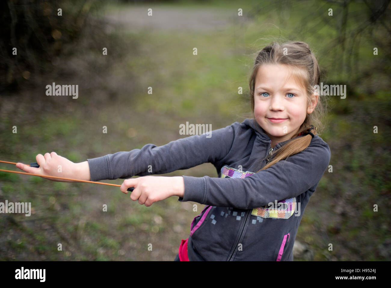 girl pulling skipping rope outdoor looking to camera Stock Photo