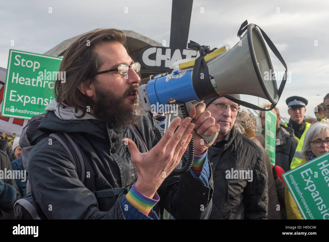 London, UK. George Barda speaks at the rally by campaigners against a third runway at London Heathrow overlooking the airport as Risingup activists blocked the M4 junction nearby bringing traffic to a standstill. They say Expansion at Heathrow will cause the UK to break its own national laws to reduce emissions, as well as undermining the international climate commitments agreed in Paris, and that the new runway will devastate local communities with families losing their homes and many over a wider area suffering dangerous levels of air pollution. Credit:  Peter Marshall/Alamy Live News Stock Photo