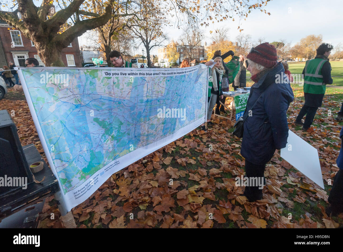 London, UK. 19th November 2016. A woman studies the map showing the flightpaths and aircraft noise at the rally on Richmond Green organised to support Zac Goldsmith who resigned to stand as an anti-Heathrow expansion candidate. The event was supported by Richmond Heathrow Campaign, Teddington Action Group, SHE (Stop Heathrow Expansion), Residents Against Aircraft Noise(RAAN), Chiswick Against the Third Runway and others campaigning against the noise, pollution and catastrophic climate change the third runway and expansion of aviation would cause. Credit:  Peter Marshall/Alamy Live News Stock Photo