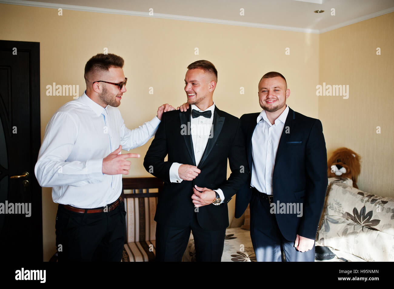 Three handsome male friends meet and speeking each other. Groomsman or best man greeting groom at wedding day. Stock Photo