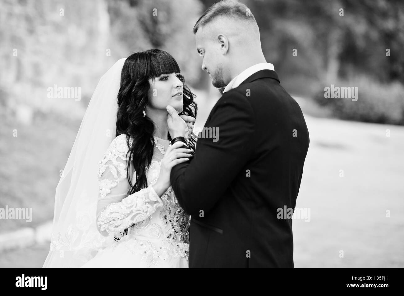 Close up portrait of stylish kissing wedding couple. Black and white photo Stock Photo