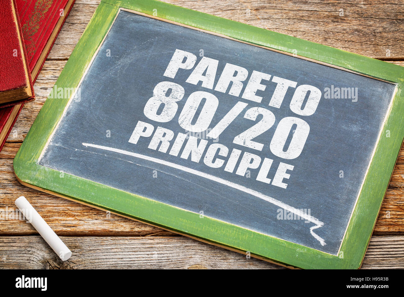 Pareto principle or eighty-twenty rule - white chalk text on a vintage blackboard blackboard with books Stock Photo