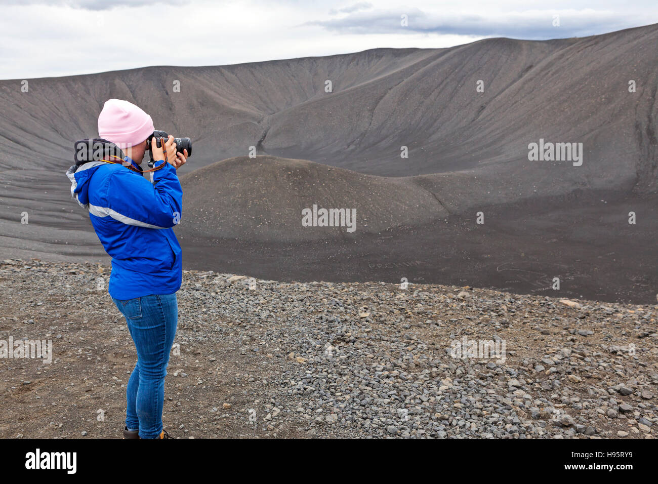 A young lady taking a picture of the Hverfjall Volcanic Crater in Iceland. Stock Photo