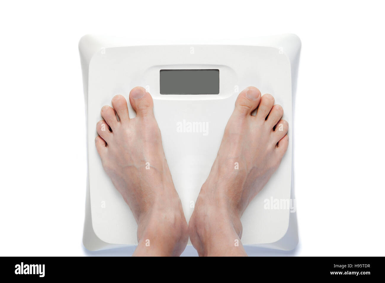 Feet on bathroom scale with a blank digital screen for copy space. Signifies either overweight or underweight health problems requiring proper dieting Stock Photo