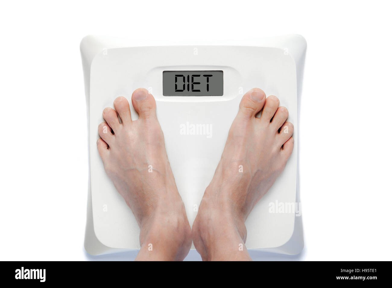 Feet on bathroom scale with the word DIET on screen. Signifies either overweight or underweight health problems requiring proper dieting. Stock Photo
