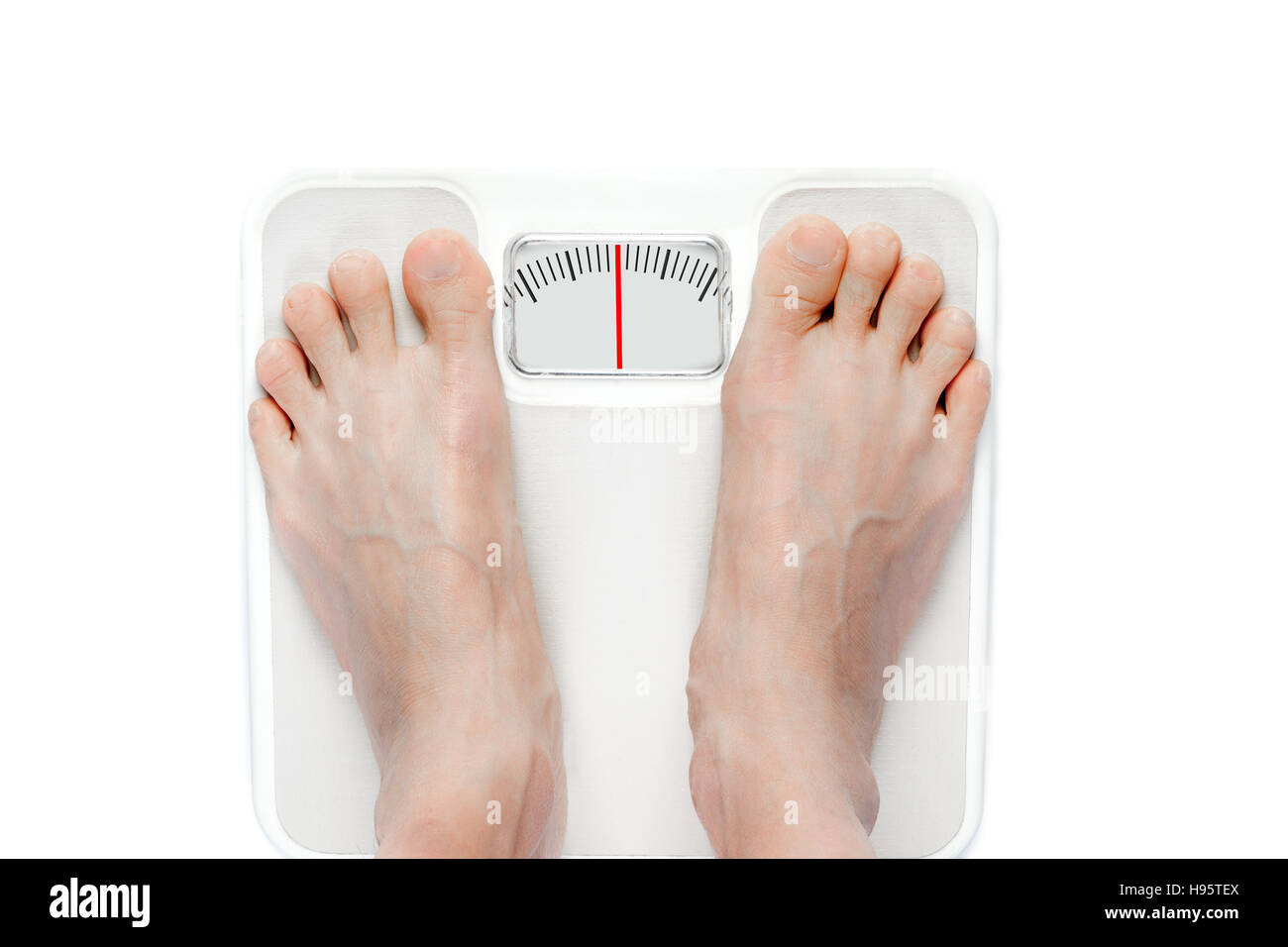 Feet on mechanical bathroom scale with a blank scale reading on screen for copy space. Stock Photo