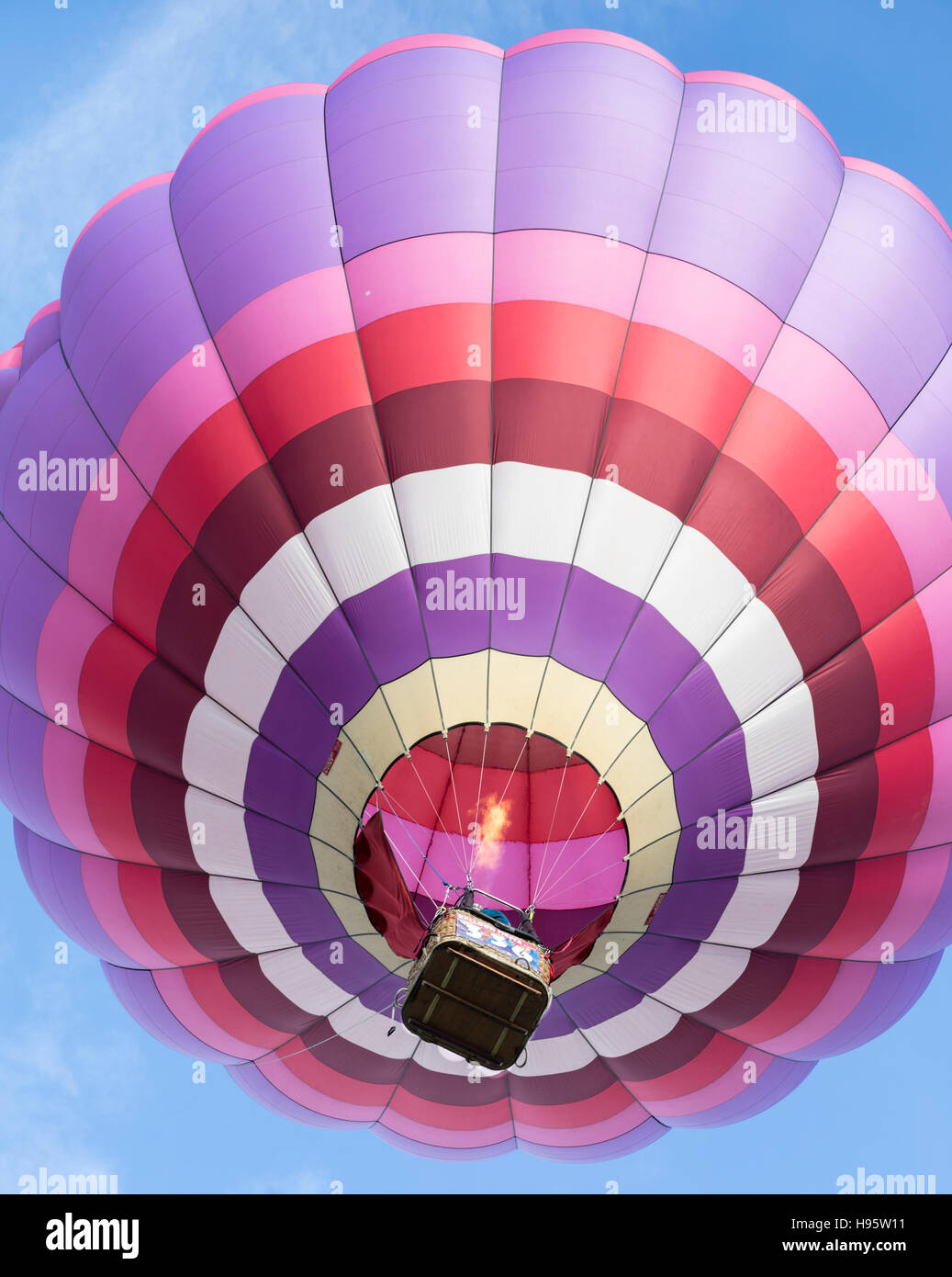 Hot air balloon gas flame is visible as it rises during mass ascension at Albuquerque International Balloon Fiesta, New Mexico Stock Photo