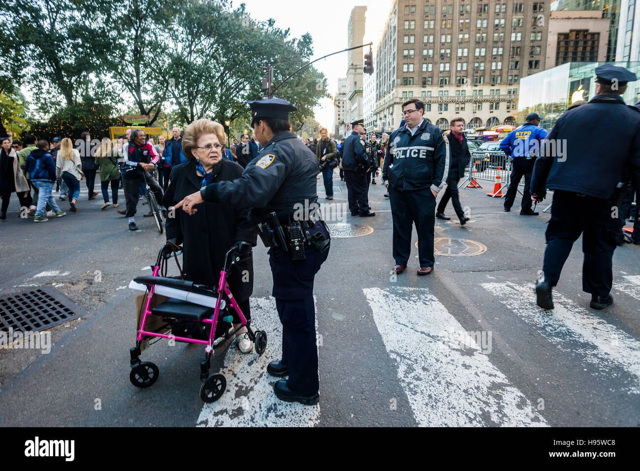 New York, USA 13 November 2016 - NYPD Police Officers prevent a woman with a walker from crossing Fifth Ave due to security around Trump tower, home of President Elect Donald Trump. New York City Mayor Bill deBlasio and the Secret Service announced traffic closures and security meansure for the time when the President Elect is in town, leading up to the inauguration, and said the City would seek Federal reinbursement for security costs. Stock Photo