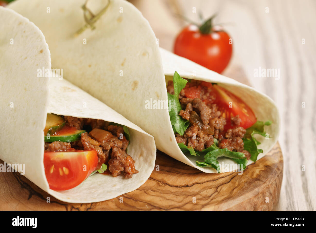 homemade tortilla with beef, frillice and vegetables on wooden board Stock Photo