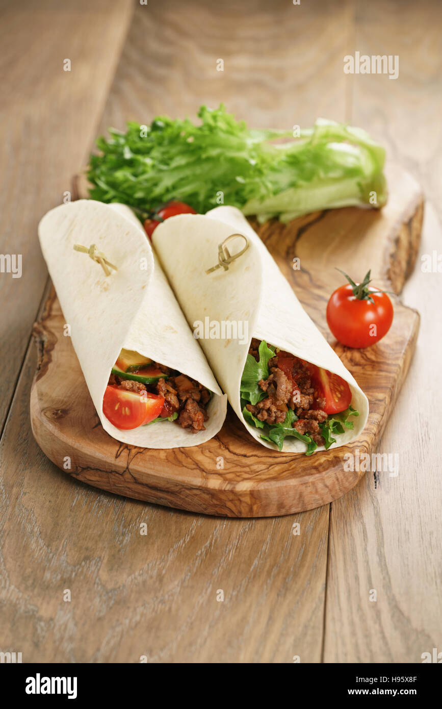 homemade tortilla with beef, frillice and vegetables on wooden board Stock Photo