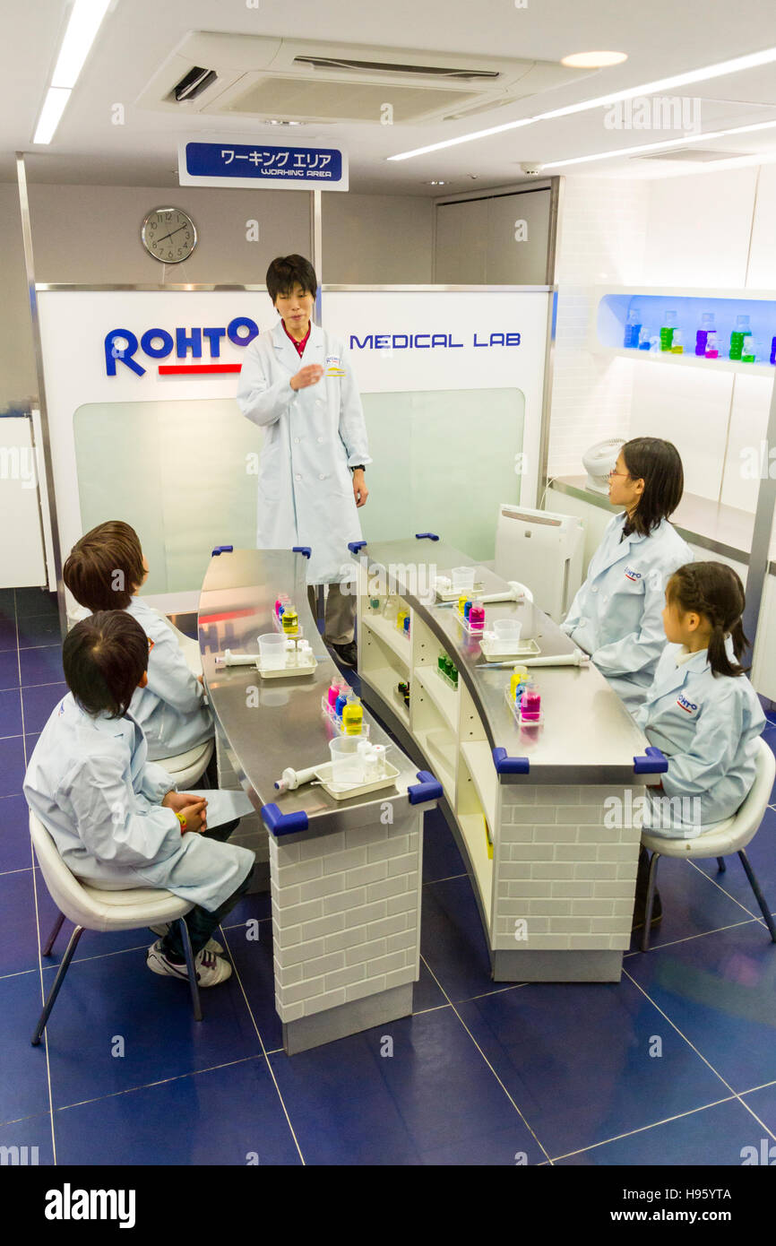 Japan, Nishinomiya, KidZania, children activity play park. Children in white coats sitting listening to lecturer in Rohto Medical lab Stock Photo