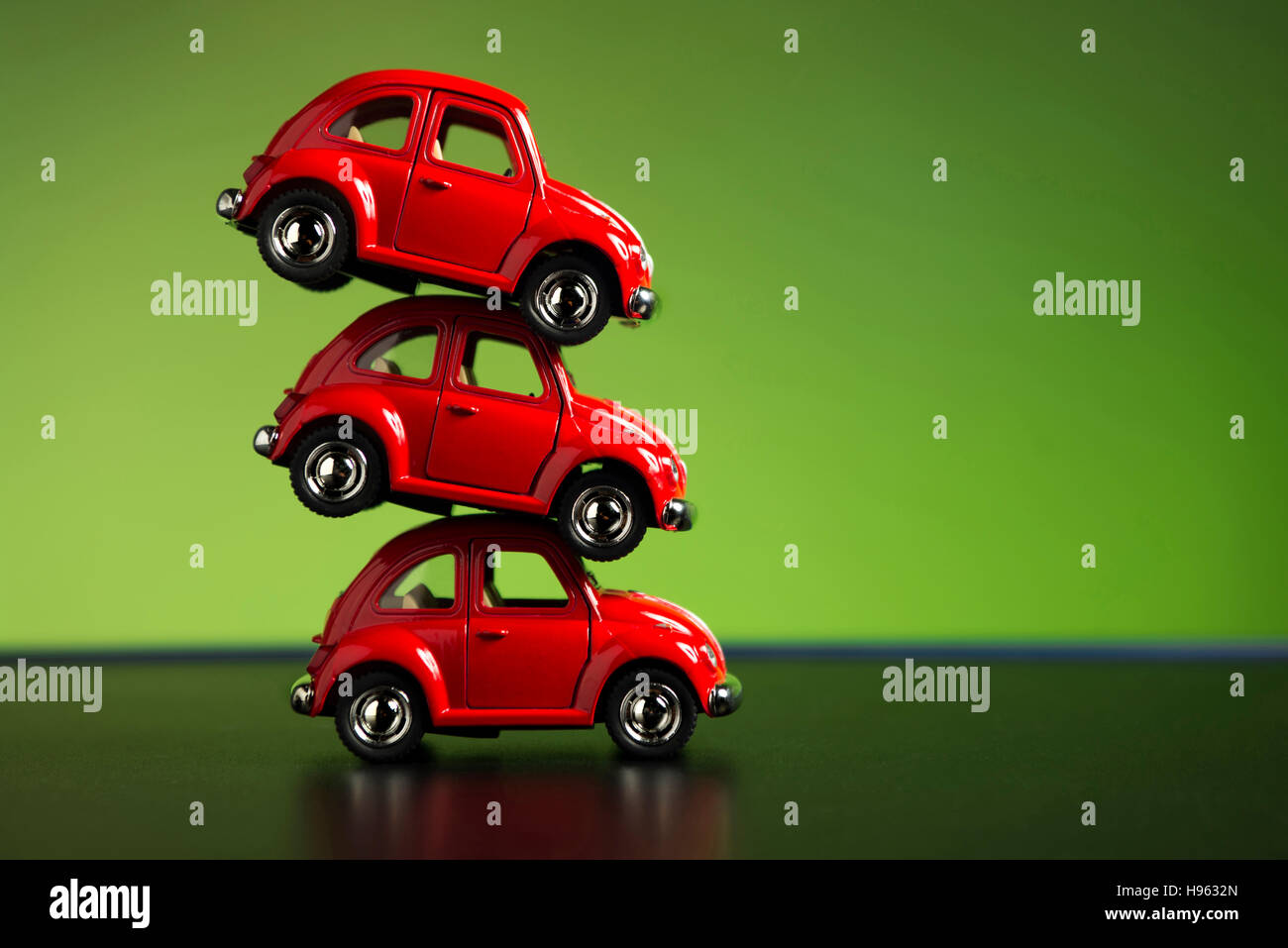 Izmir, Turkey - July 23, 2015. Stacked 3 red Volkswagen beetles on a green background. Stock Photo