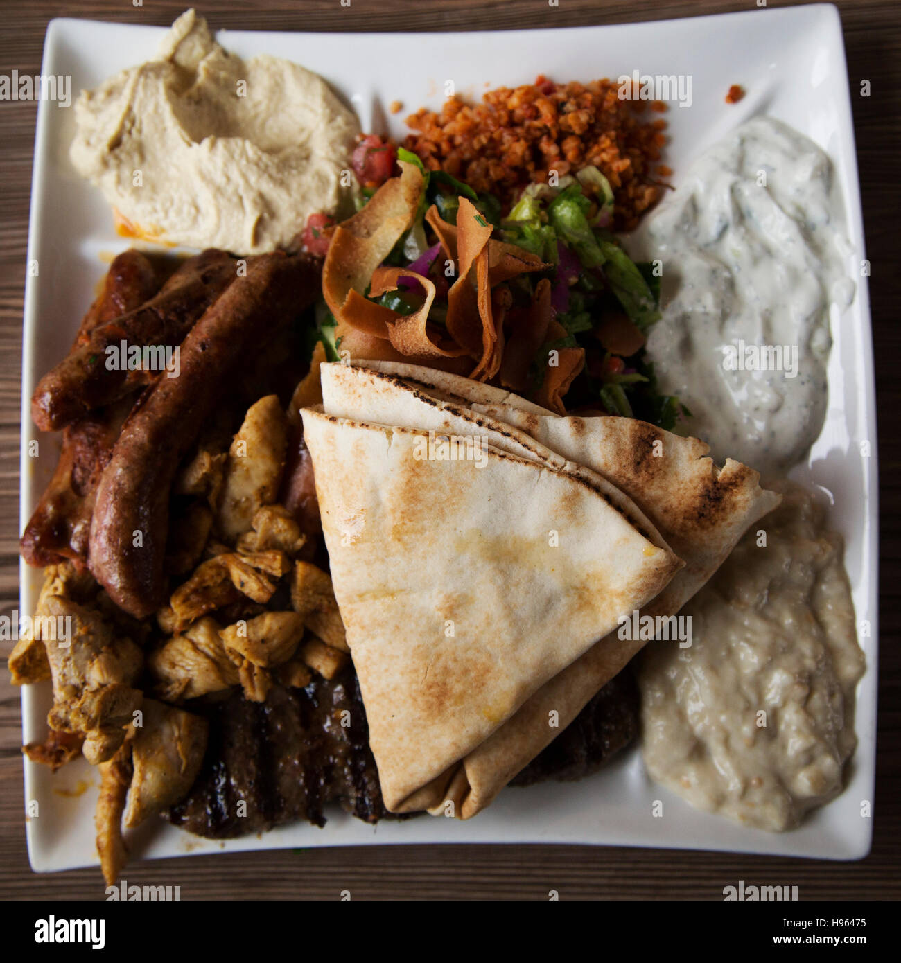 A North African style cuisine served in the Markthal in Rotterdam, the Netherlands. The platter features a mixed grill of meats, a salad and dips. Stock Photo