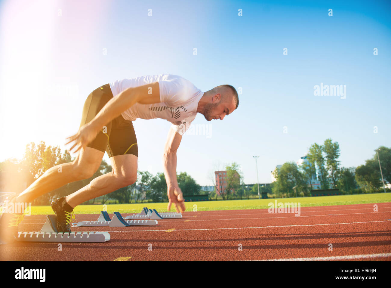 Male athlete on starting position at athletics running track Stock Photo -  Alamy