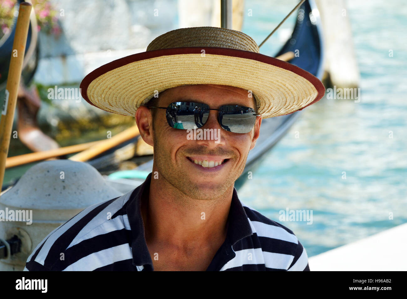 Gondolier with the typical headgear on a canal of Venice in Italy. Stock Photo
