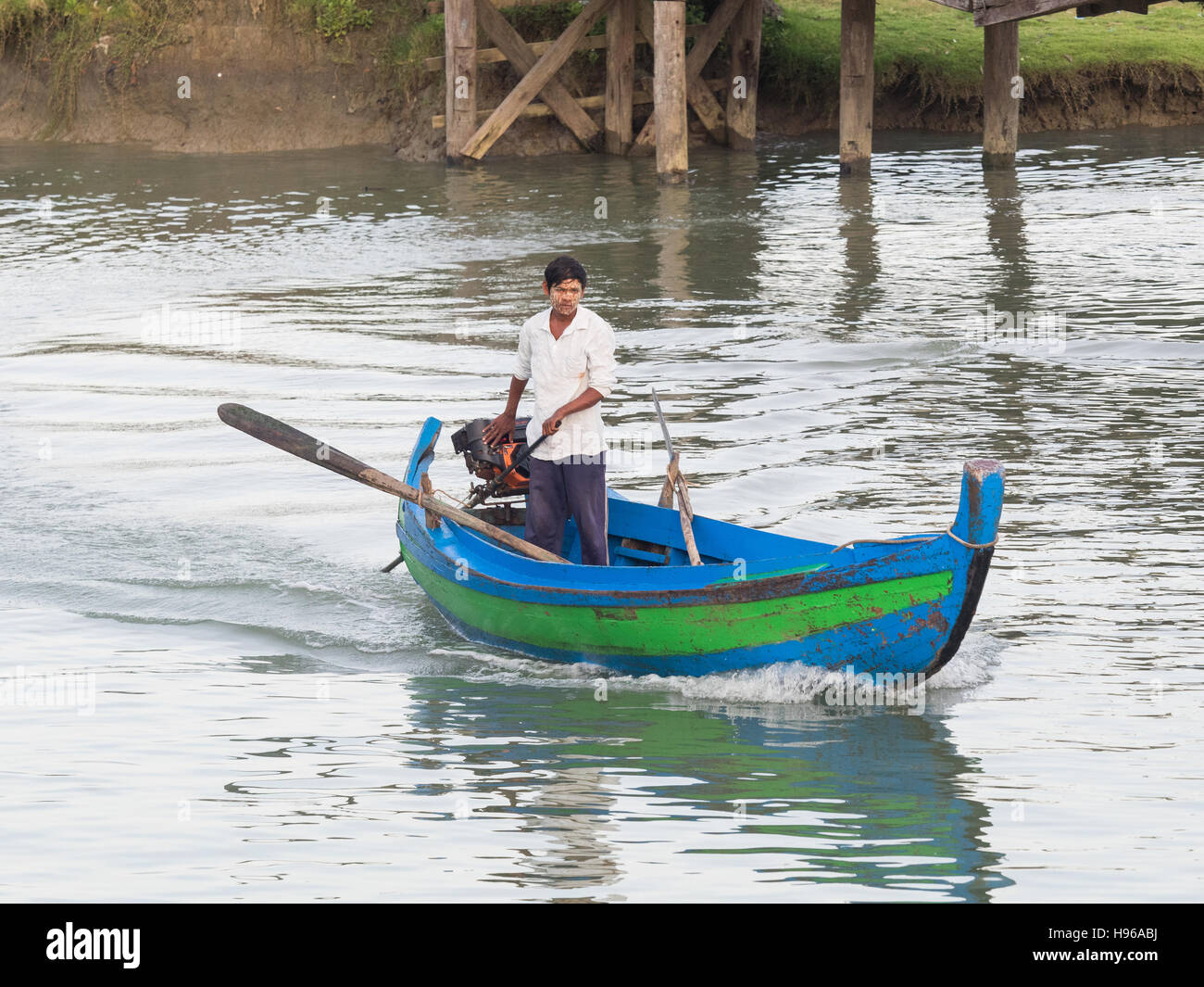 Man manouvring his traditional wooden boat on a canal in Sittwe, the capital of the Rakhine State, Myanmar Stock Photo