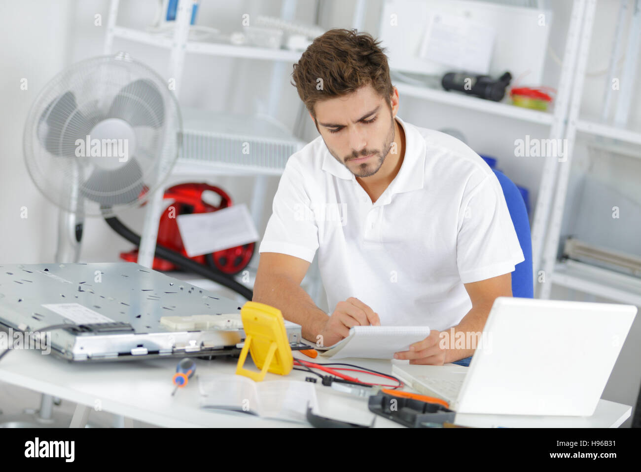 young engineer taking notes while developping new induction hobs Stock
