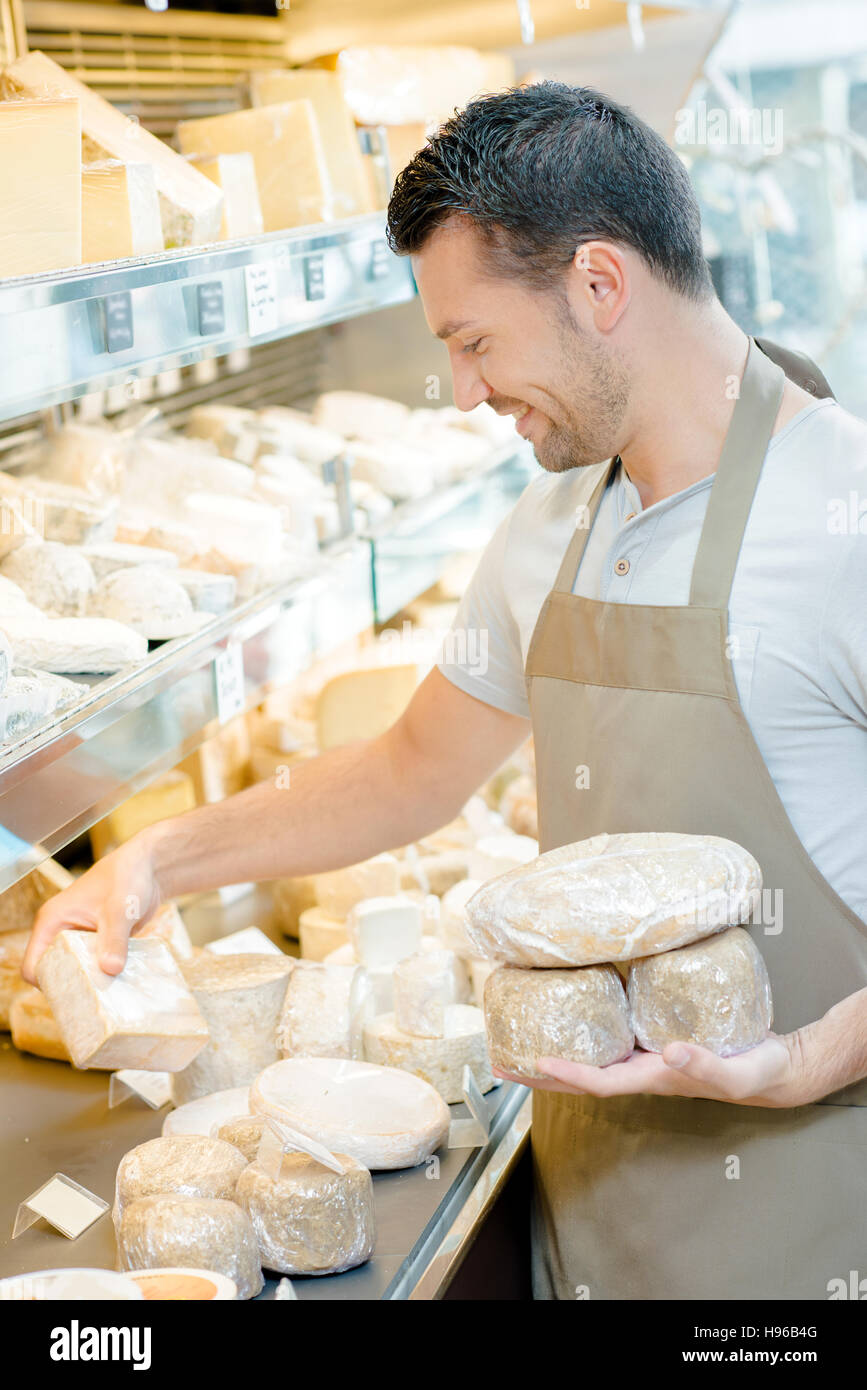 Man stocking the shelves in a cheese shop Stock Photo