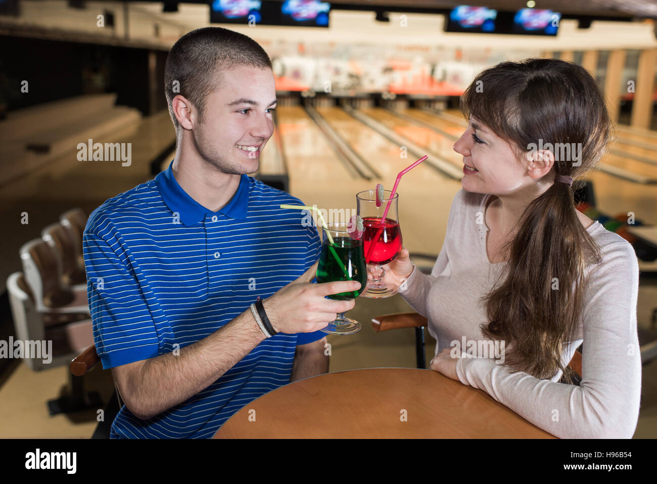 young couple on a date behind table in bowling club Stock Photo