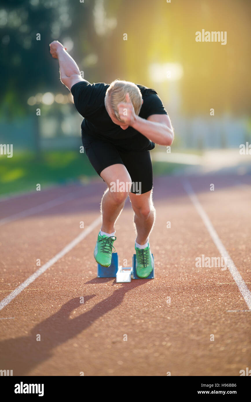 Sprinter leaving starting blocks on the running track. Explosive start ...