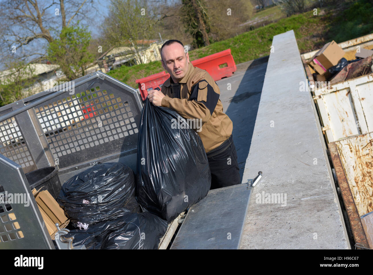 garbage collector loading trash bag in truck Stock Photo Alamy