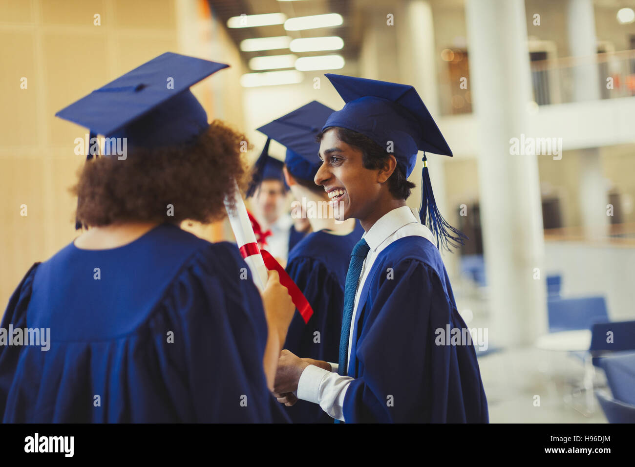 Smiling college graduates in cap and gown Stock Photo