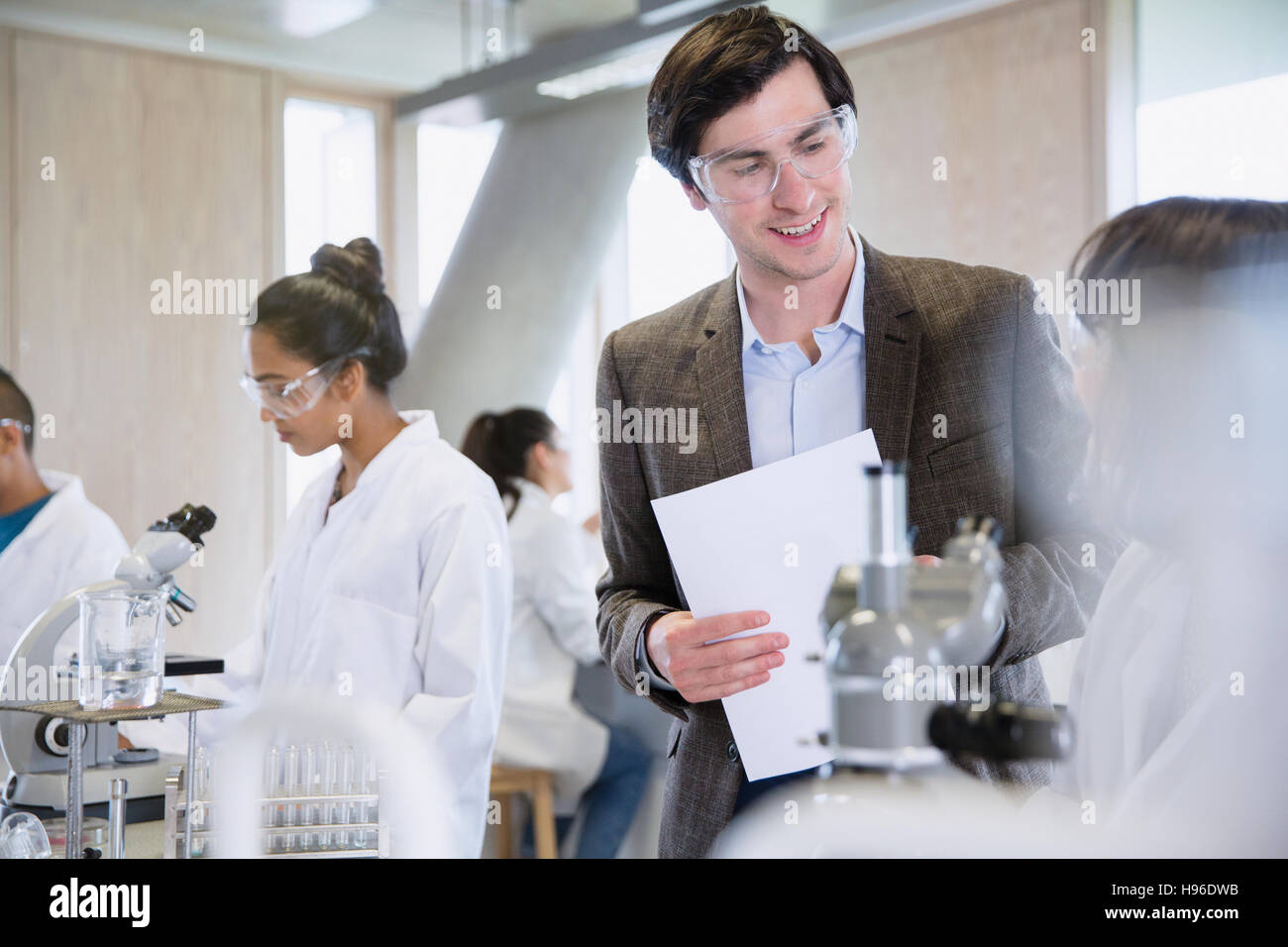 Science professor helping college student in science laboratory