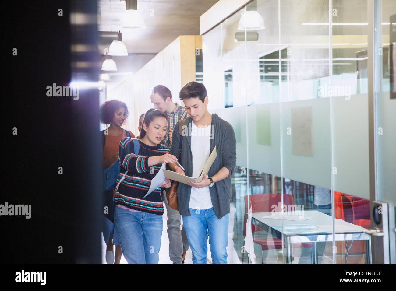 College students discussing homework in corridor Stock Photo