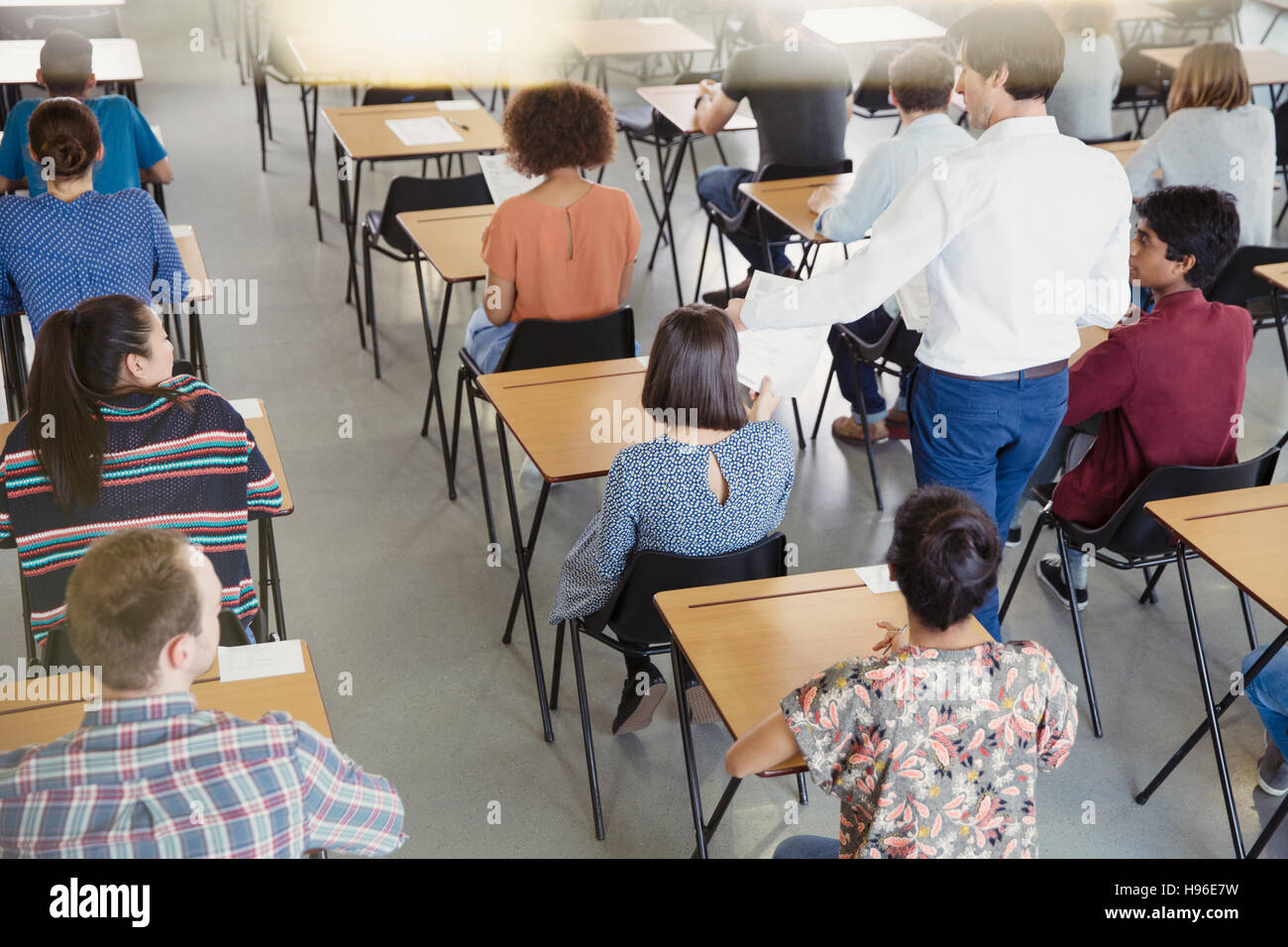 Professor collecting test from students in classroom Stock Photo - Alamy
