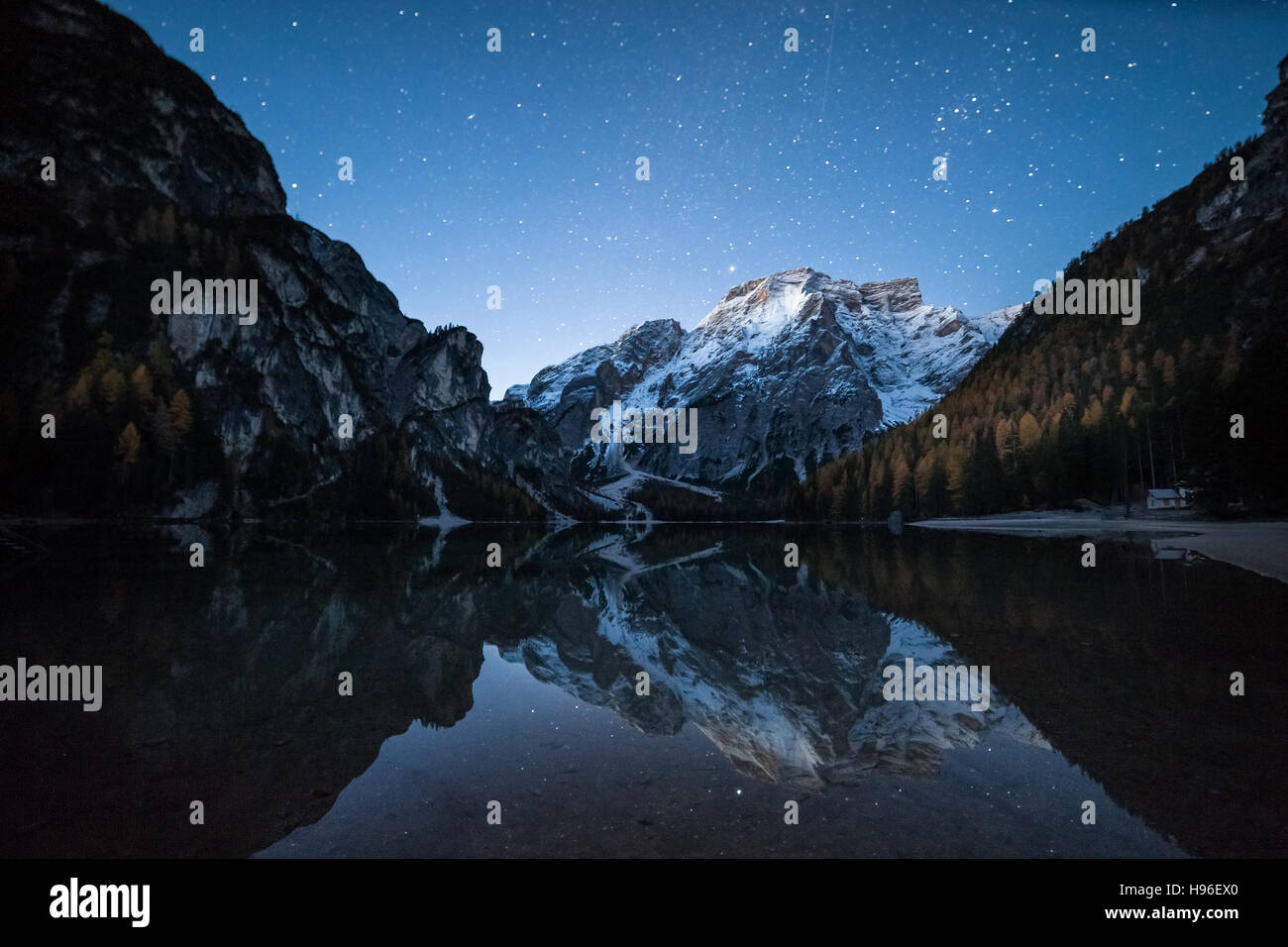 Night landscape with stars over lake and mountain, Braies, Italy Stock Photo